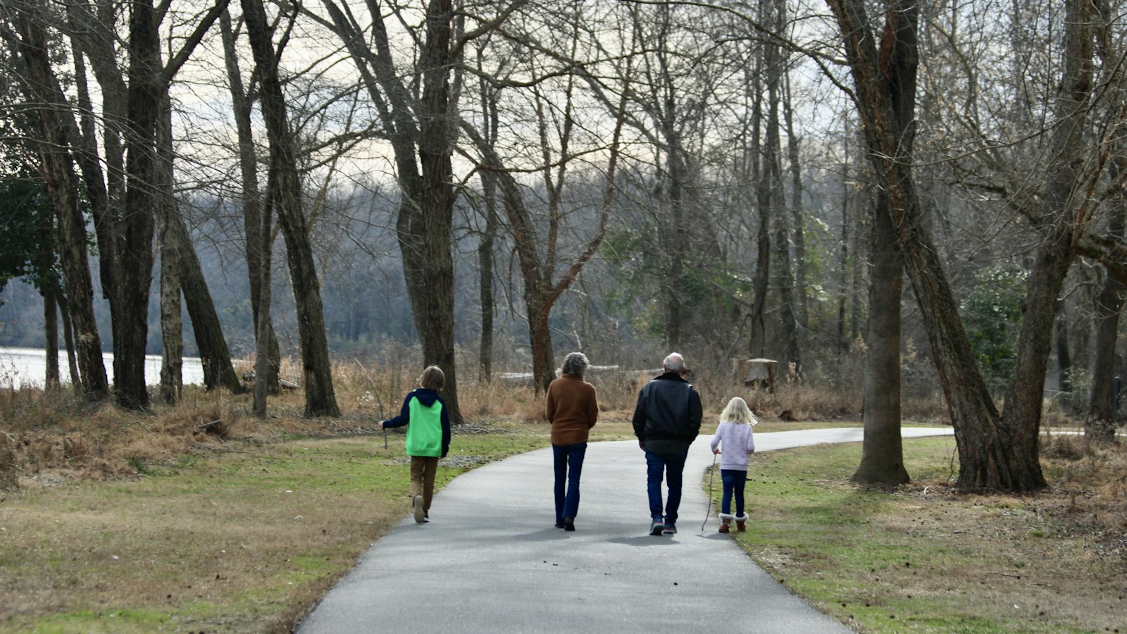 Family walking together in a park in Vernon, BC with hills in the background