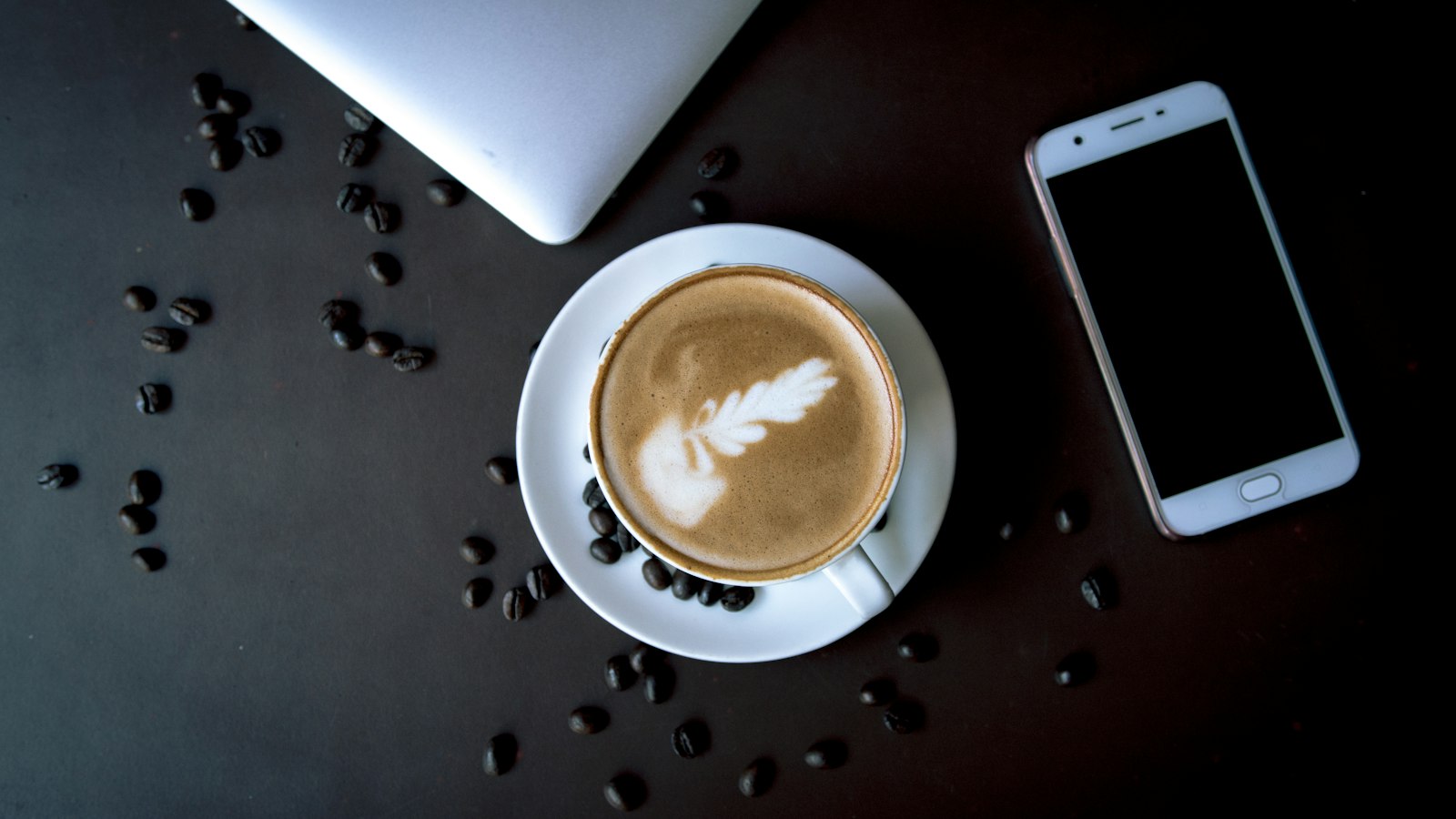 Two people talking over coffee at a kitchen table, like a seller interviewing a Vernon realtor