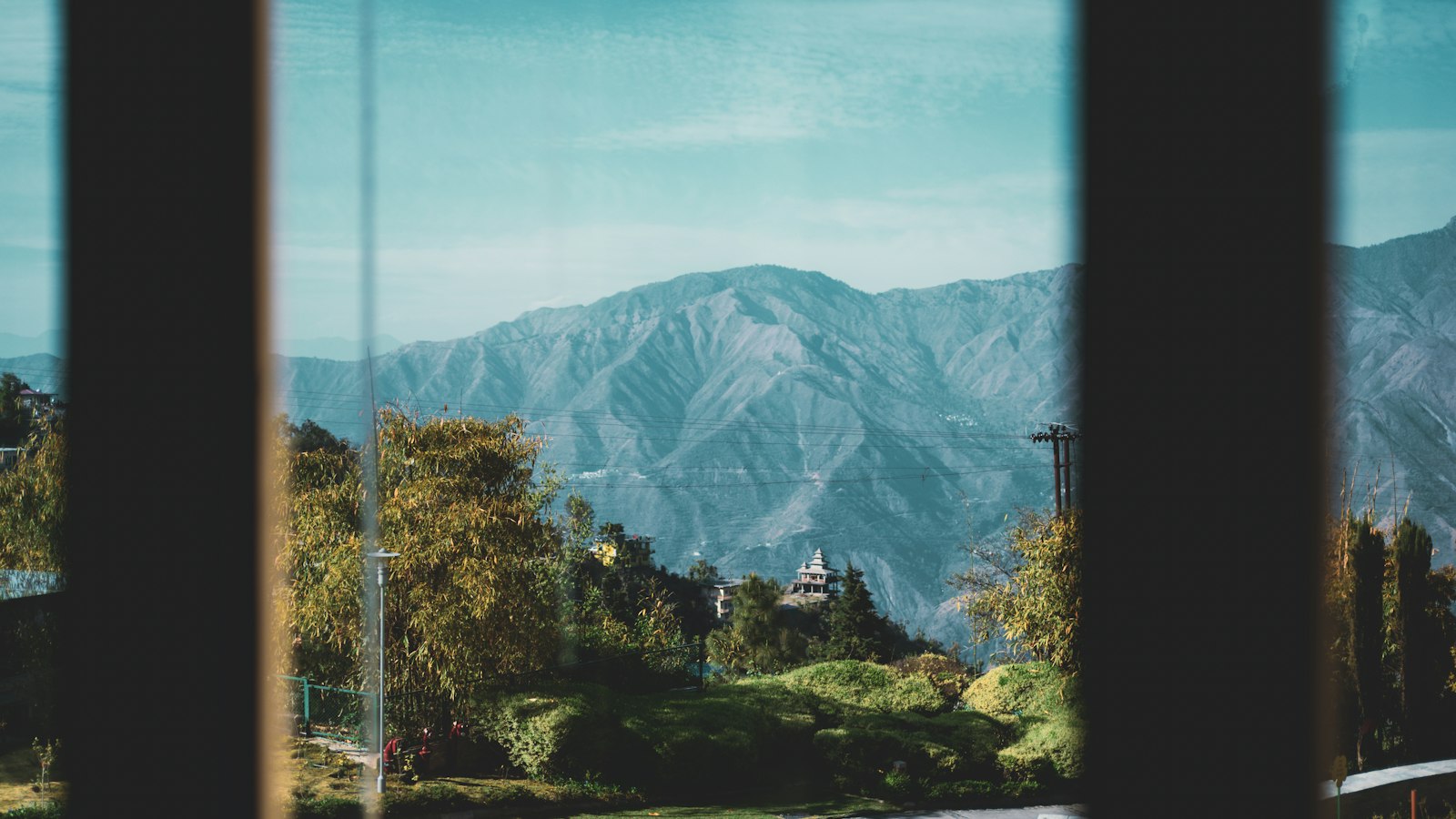 A home office desk with a laptop and a window looking out at mountains